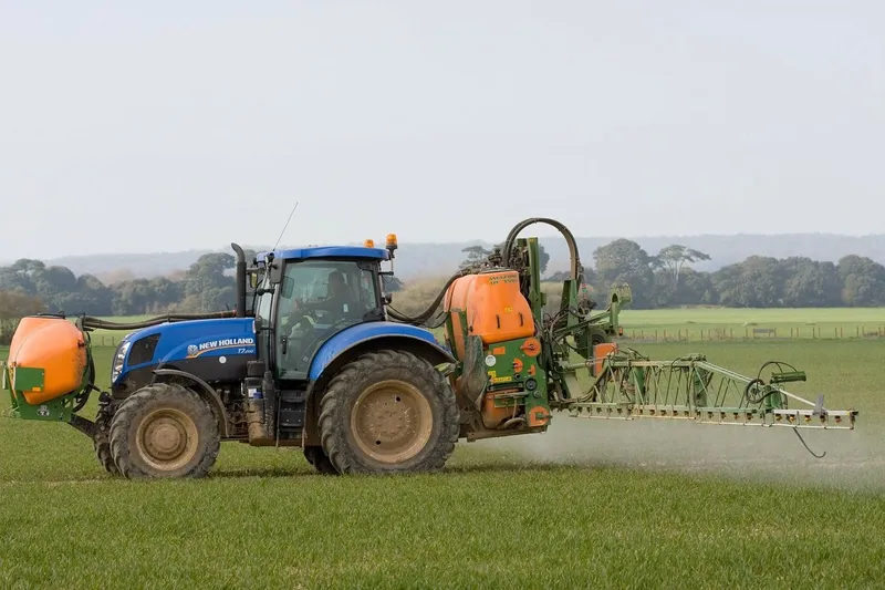 Traktor podczas oprysku środkami ochrony roślin upraw